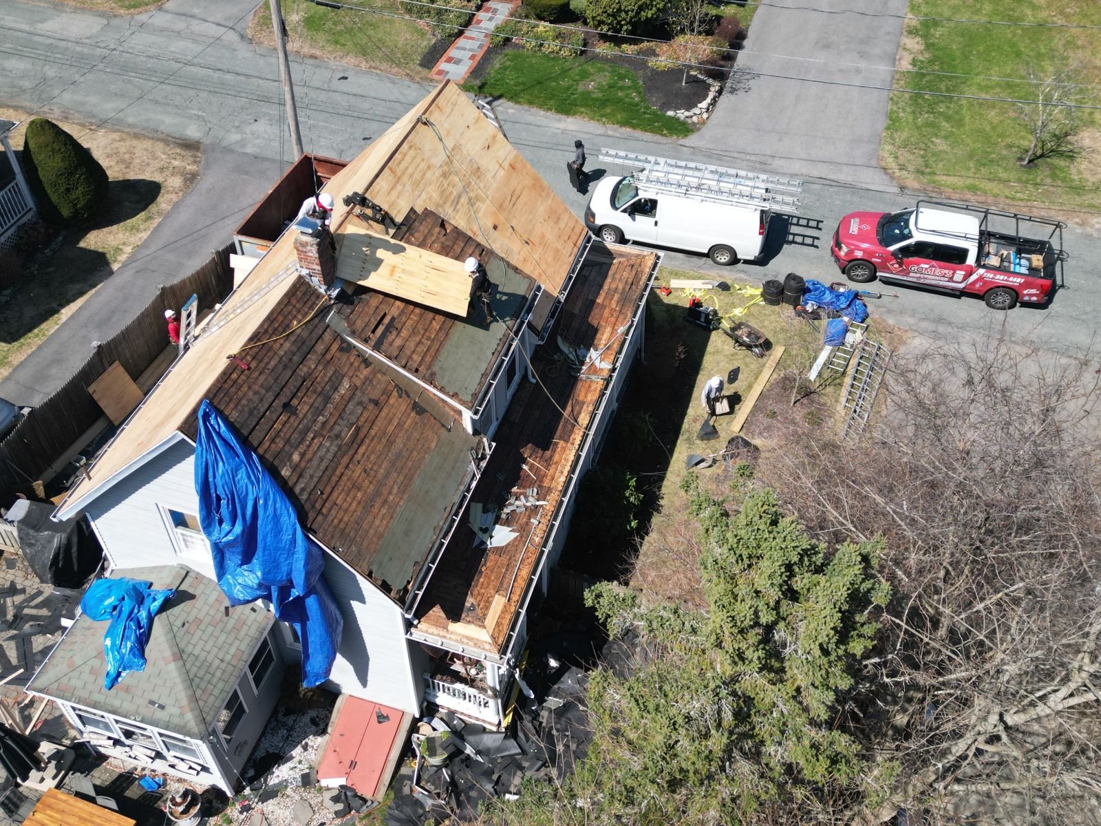 Damaged roof under tear-off with a protective tarp