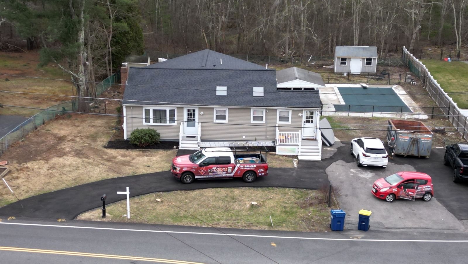 Gomes's Construction trucks parked in front of a finished home in Massachusetts