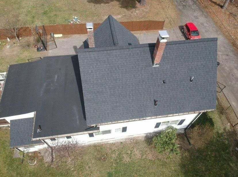 Completed charcoal roof on a white colonial home