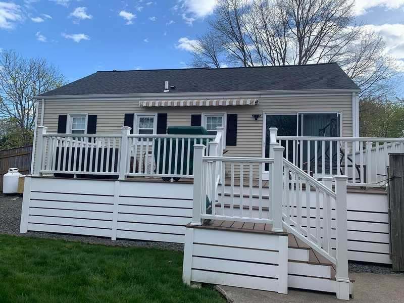 Home with new siding and a white deck
