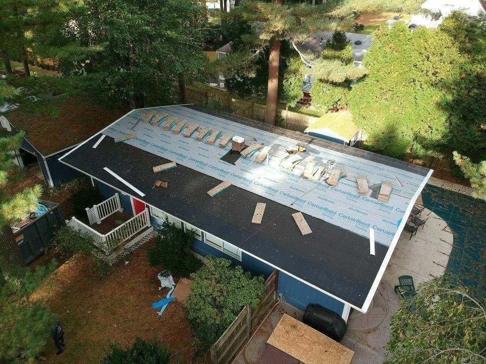 Roof replacement in progress on a blue home